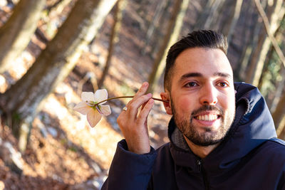 Young man joking with a white flower