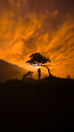 Silhouette man on field against sky during sunset