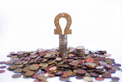 Close-up of coins on metal against white background