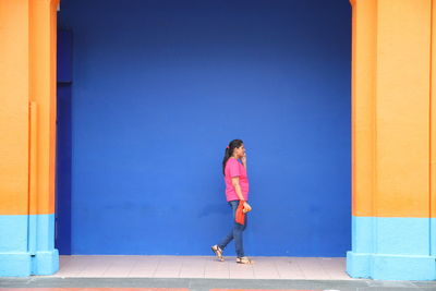 Full length of woman against blue sky