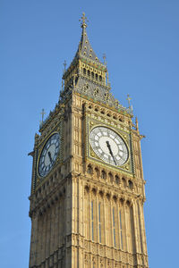 Low angle view of clock tower against blue sky