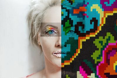 Digital composite image of woman with make-up and colorful pattern against wall