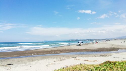 Scenic view of beach against blue sky