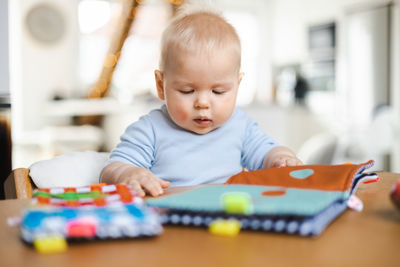 Portrait of cute boy playing with toy blocks at home