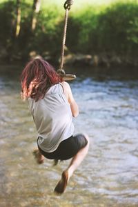 Woman swinging over lake