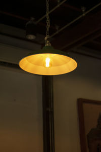 Low angle view of illuminated pendant light hanging from ceiling