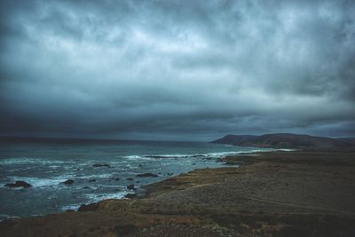 Scenic view of sea against storm clouds