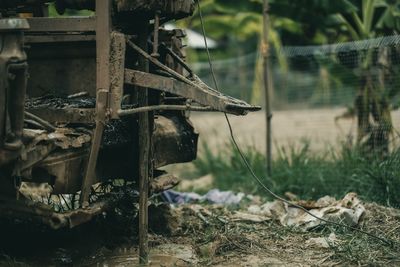 Close-up of abandoned metallic structure on field