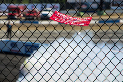 Close-up of shoes on chainlink fence
