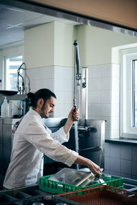 Side view of man working in kitchen