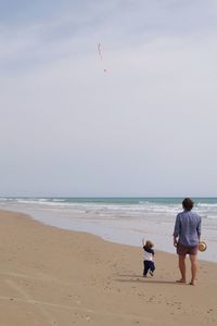 Rear view of father and child on the beach