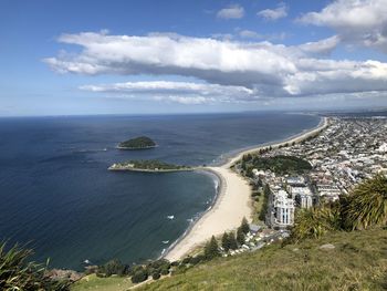 High angle view of city by sea against sky