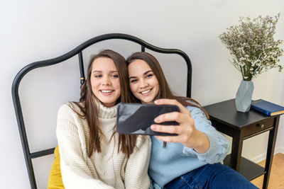 Portrait of smiling young woman using mobile phone