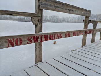 Wooden fence on snow covered field during winter