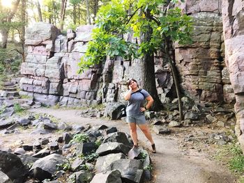 Woman standing on rock by tree