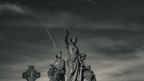 Low angle view of statues against sky