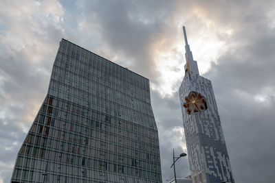 Low angle view of buildings against cloudy sky