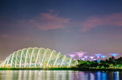 Reflection of illuminated building in lake at sunset