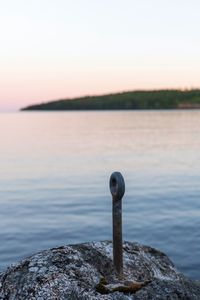 Close-up of rocks on sea against sky during sunset