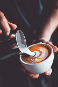 Cropped image of hand holding coffee cup