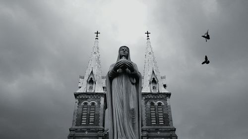 Low angle view of building against cloudy sky