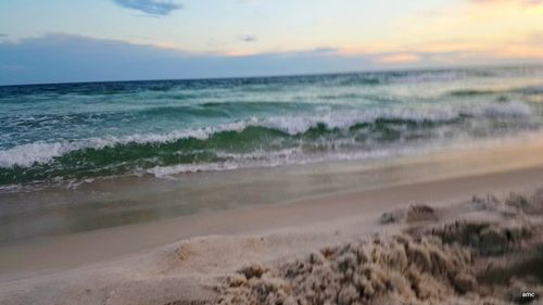 Scenic view of beach against sky during sunset