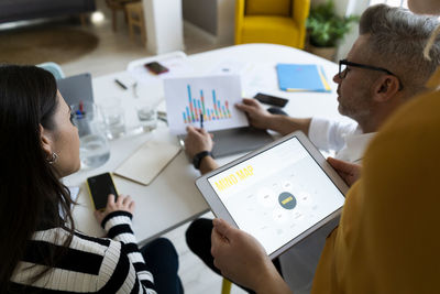 Businessman examining graph report with colleagues at office