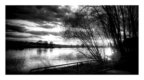 Scenic view of river against cloudy sky