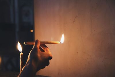 Close-up of hand holding candles