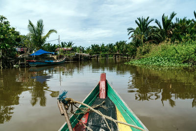 Fishing boat in river against sky