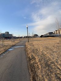 Road amidst buildings against sky