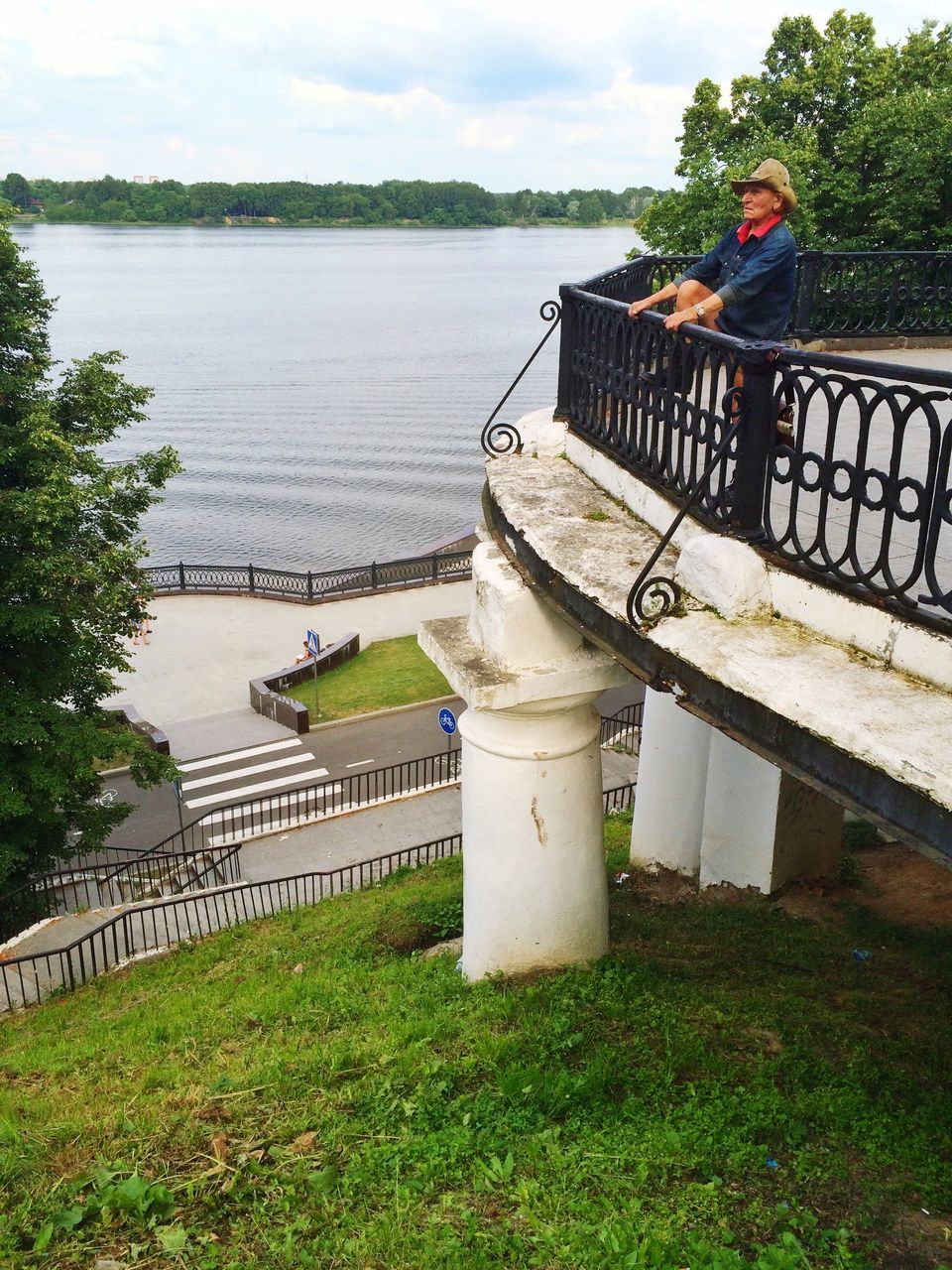 water, grass, railing, river, sky, sea, built structure, nature, tranquility, lake, pier, tranquil scene, architecture, bench, bridge - man made structure, outdoors, transportation, day, high angle view, tree