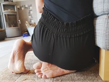 Low section of woman sitting at home
