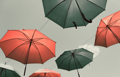 Low angle view of umbrellas hanging against sky