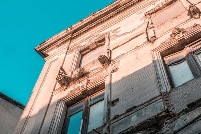 Low angle view of old building against blue sky