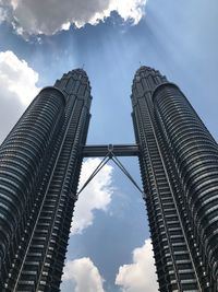 Low angle view of buildings against cloudy sky