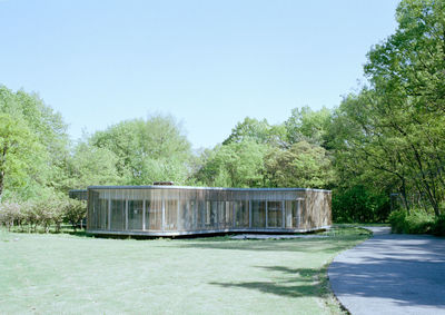 Built structure by trees against clear sky