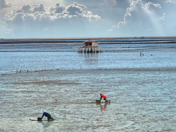 People on beach against sky
