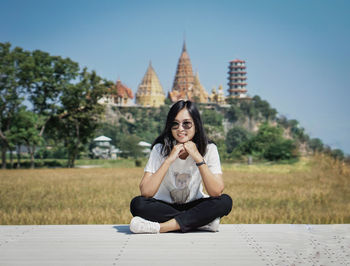 Portrait of woman sitting against plants