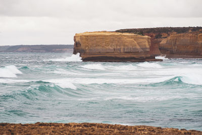 Rock formations in sea against sky