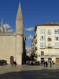 People walking on road against buildings