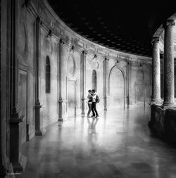 Rear view of man walking in corridor of building