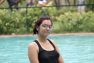 Portrait of young woman standing in pool