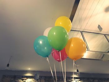 Multi colored balloons on water against sky