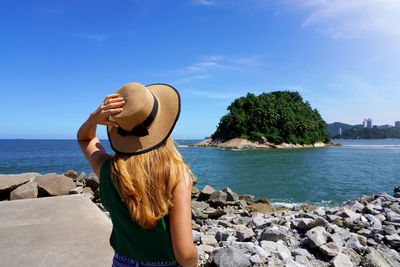Traveler girl looking the uninhabited urubuqueçaba island near santos coast baixada santista, brazil