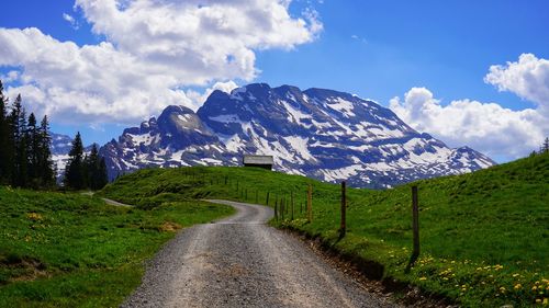 Road leading towards mountains against sky