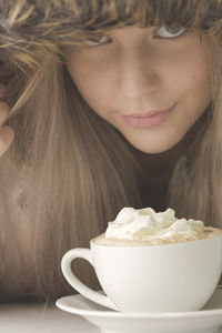 Close-up portrait of teenage girl with drink at table