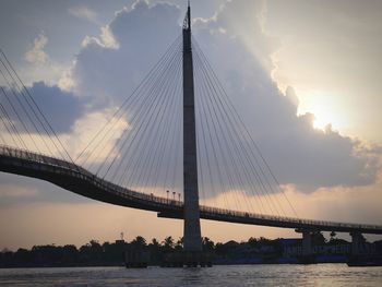 View of suspension bridge against cloudy sky
