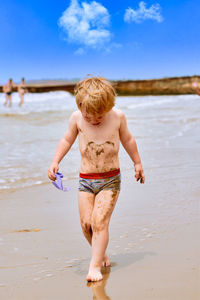 Full length of shirtless boy on beach