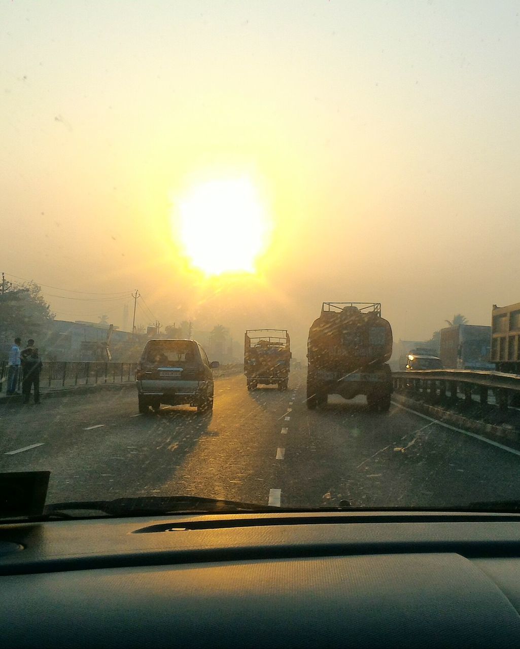 CARS ON ROAD AGAINST SKY DURING SUNSET